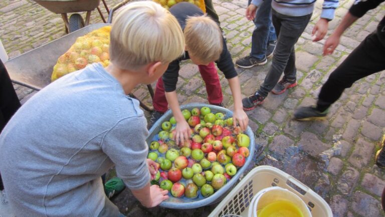 Kinder waschen Äpfel in einer Wanne