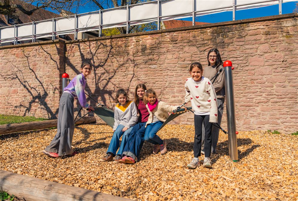 Kinder sitzen auf einer Hängematte