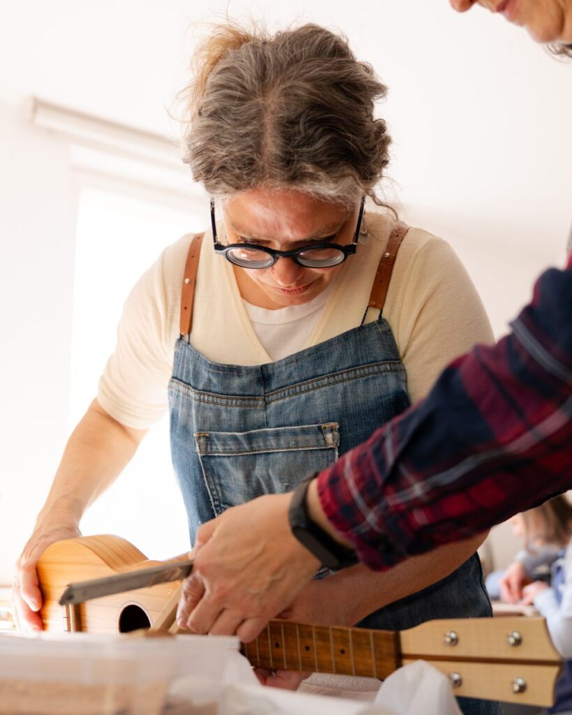 eine Frau betrachtet konzentriert ein zu fertigendes Instrument