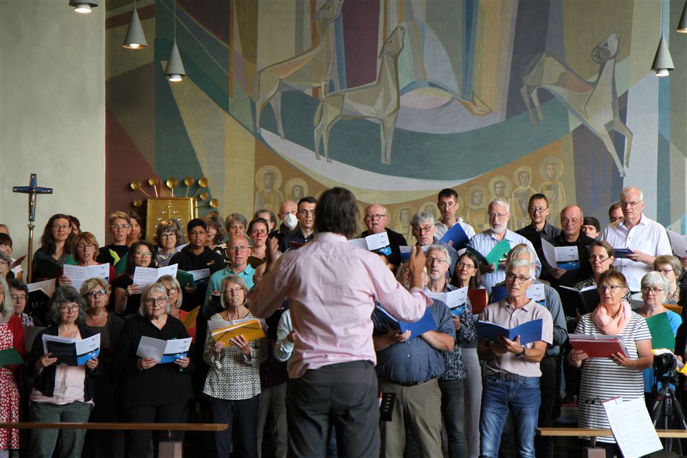 ein singender Chor in der Kirche, eine Person dirigiert