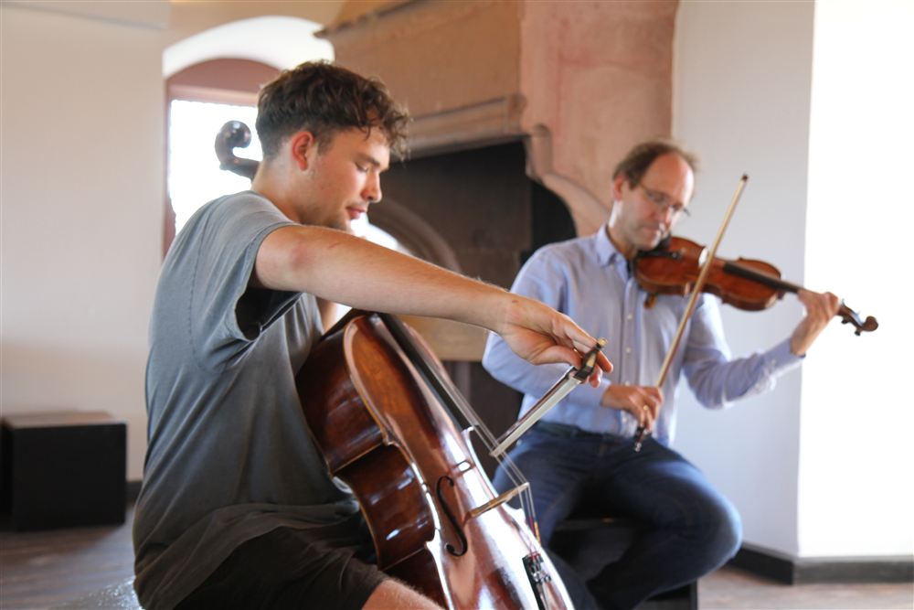 zwei Personen musizieren mit Streichinstrumenten