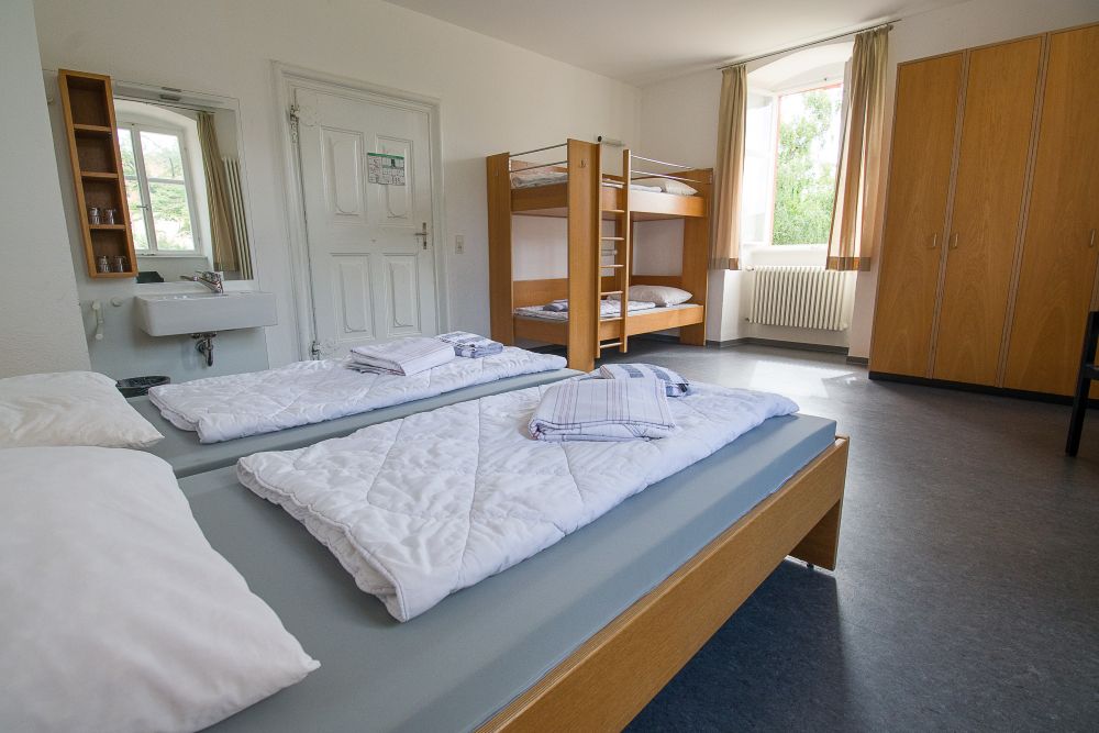 Familienzimmer mit einem Doppelbett und einem Stockbett, ausgestattet mit einer Waschgelegenheit